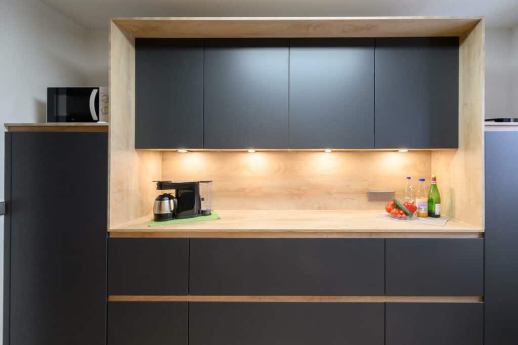 Kuechenhalle-Design-Kuechenzeile-zweizeilig-griffmulden-matt-Holz-Arbeitsplatte
