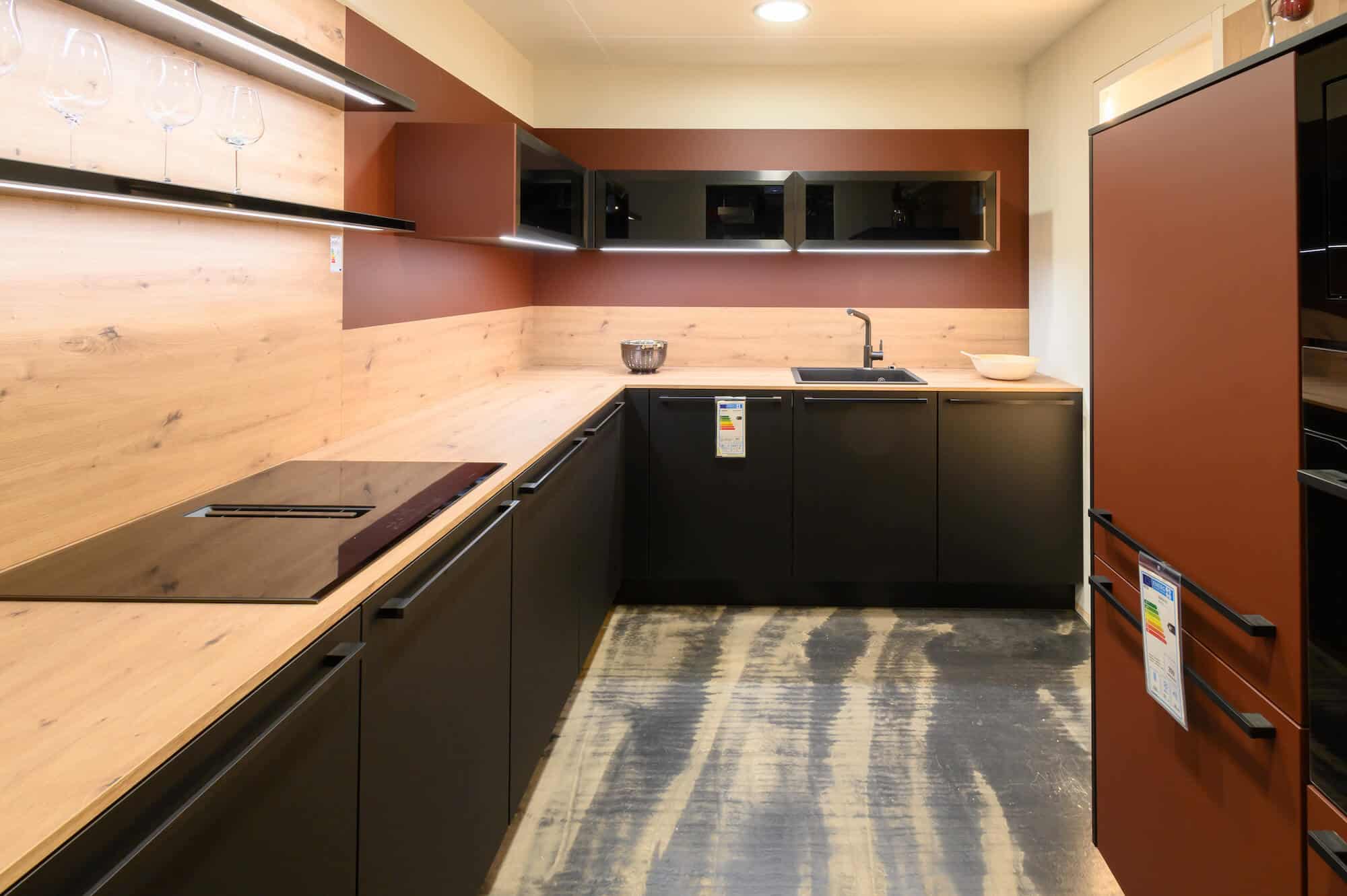 Moderne L-Küche schwarz matt lack mit Holz Arbeitsplatte und rotem Wandschrank
