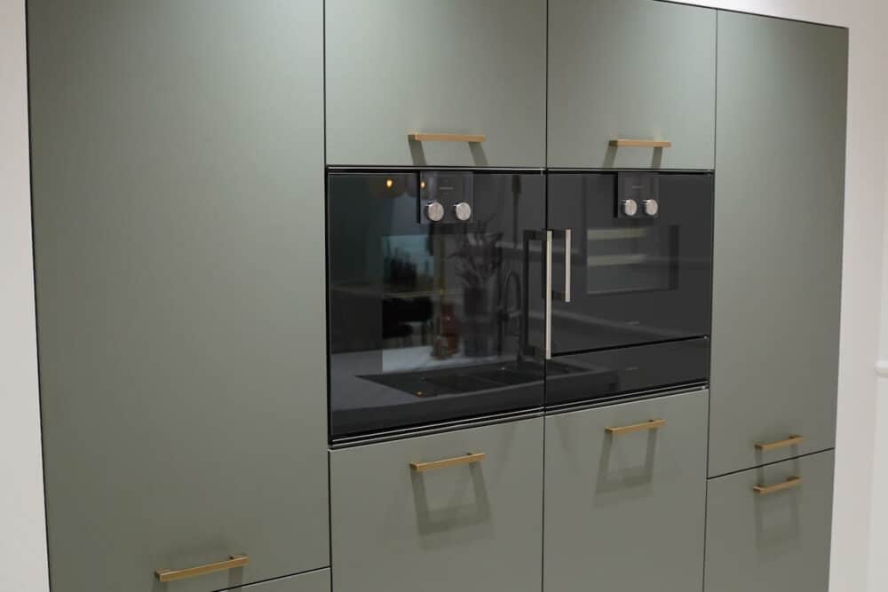 Großer Wandschrank gold Griffe mit Elektrogeräten
