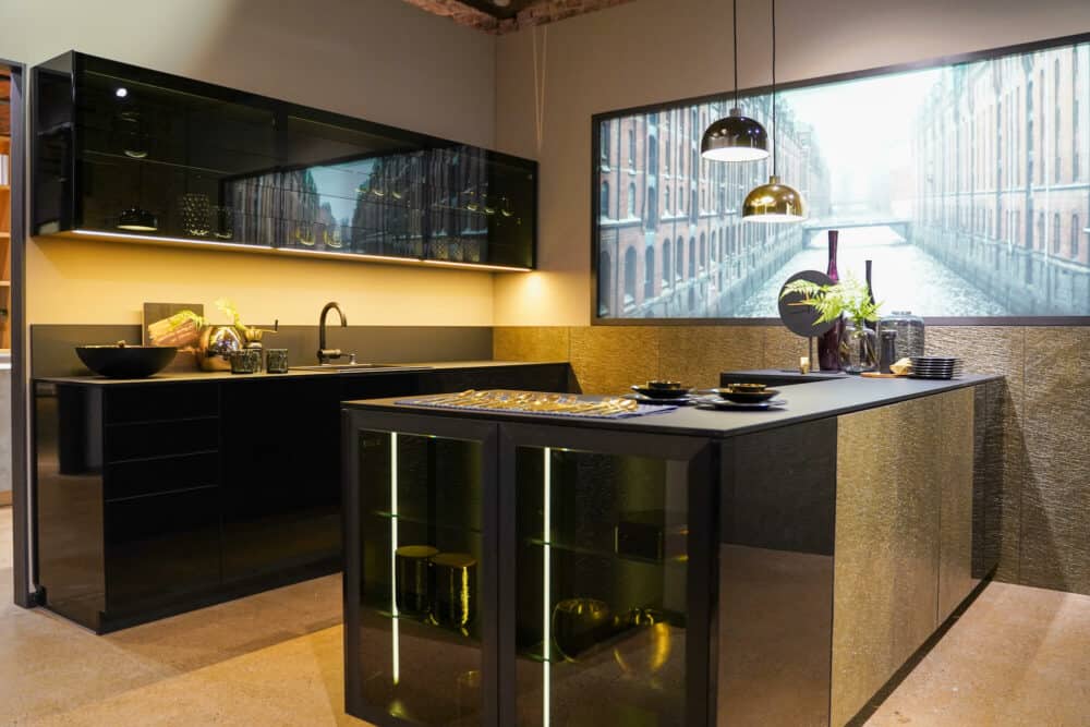Bauformat Design Inselküche schwarz hochglanz mit Gold Fronten